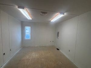 Charleston SC interior painting project in progress with masked light fixtures, window, and freshly primed white walls