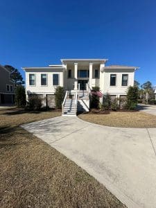 Freshly painted Charleston SC luxury home exterior with white stucco, elevated porch, and grand front staircase