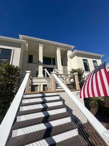 Freshly painted Charleston SC home exterior with cream stucco, white columns, and elevated front staircase