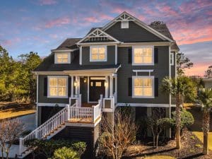 Freshly painted Charleston SC three-story home exterior with dark gray siding, white trim, and black shutters at sunset