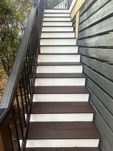 Freshly painted Charleston SC exterior staircase with brown treads, white risers, and dark wood railings