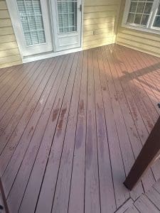 Freshly stained Charleston SC backyard deck with rich brown boards, cream siding, and white French doors