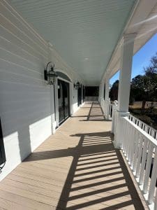Freshly painted Charleston SC front porch with white siding, columns, and pale blue ceiling