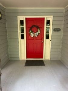 Freshly painted Charleston SC front entry with sage green siding, cream trim, and bold red door