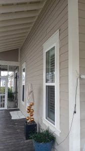 Freshly painted Charleston SC home exterior with greige lap siding, white trim, and covered porch