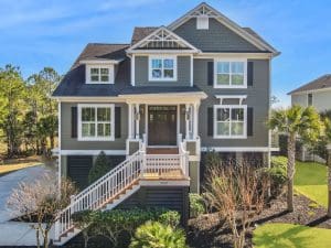 Freshly painted Charleston SC three-story home exterior with green siding, white trim, black shutters, and elevated porch