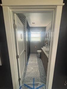 Charleston SC bathroom painting project with freshly painted white door and trim, floors masked for protection