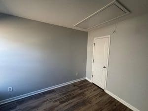 Freshly painted Charleston SC room with light gray walls, white trim, and dark hardwood floors