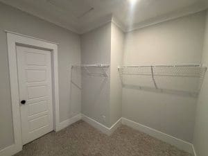 Freshly painted Charleston SC walk-in closet with light gray walls, white trim, and wire shelving