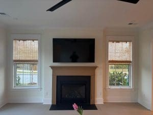 Freshly painted Charleston SC living room with warm cream walls, white trim, and tan fireplace mantel
