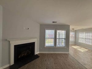 Freshly painted Charleston SC living room with gray walls, white fireplace mantel, and hardwood floors