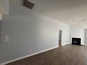 Freshly painted Charleston SC living room with light gray walls, white trim, and white fireplace mantel