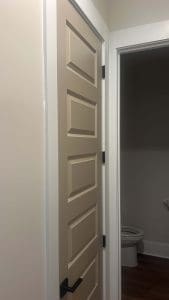 Charleston SC home interior with freshly painted greige door, white trim, and adjacent bathroom
