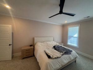 Freshly painted Charleston SC bedroom with soft greige walls, white trim, and carpet flooring