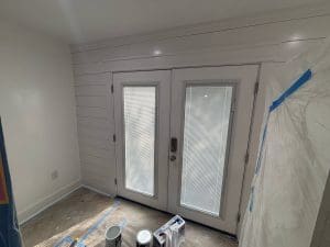 Charleston SC interior painting project in progress with freshly painted white shiplap walls and French doors