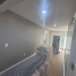 Charleston SC interior painting project with freshly painted gray walls and furniture covered in protective plastic