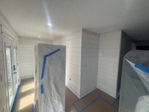 Charleston SC interior painting project with freshly painted white shiplap walls and furniture covered for protection