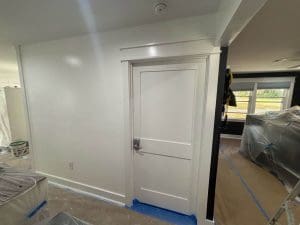 Charleston SC interior painting project in progress with freshly painted white door, walls, and masked floors