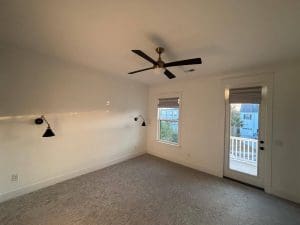 Freshly painted Charleston SC bedroom with crisp white walls, carpet, and black accent sconces
