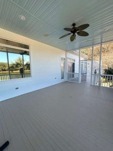 Freshly painted Charleston SC screened porch with white walls, gray deck, and pale blue ceiling