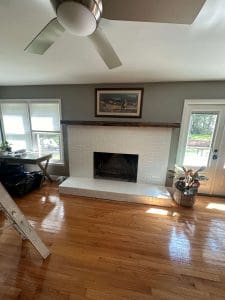 Freshly painted Charleston SC living room with gray walls and white brick fireplace