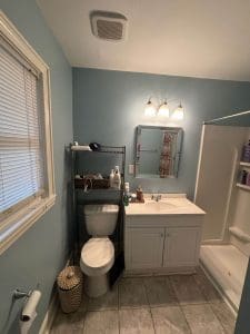 Freshly painted Charleston SC bathroom with soft blue walls, white vanity, and tile flooring