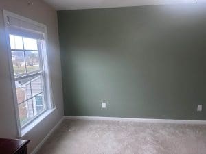 Freshly painted Charleston SC room with greige walls, sage green accent wall, and white trim